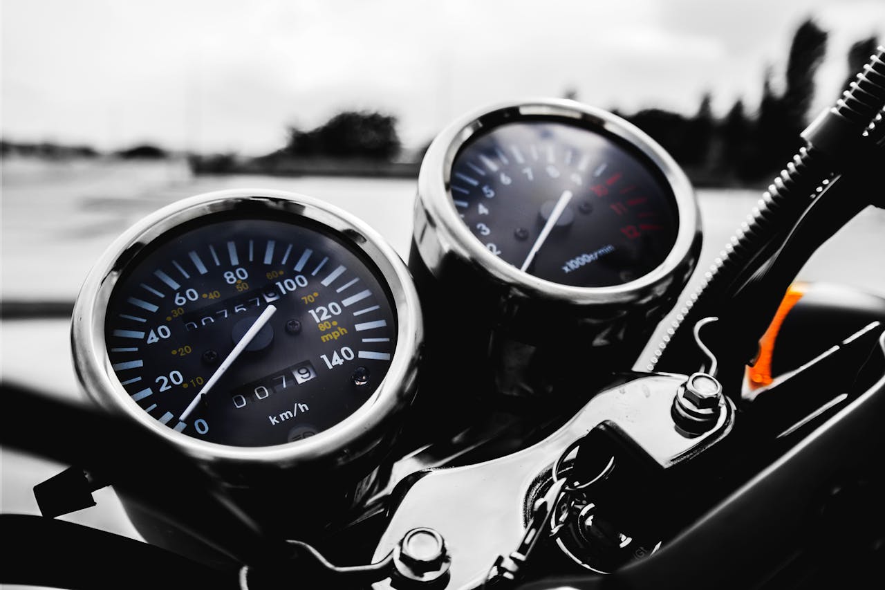 Detailed shot of a motorcycle's speedometer and tachometer in focus, showcasing precision engineering.